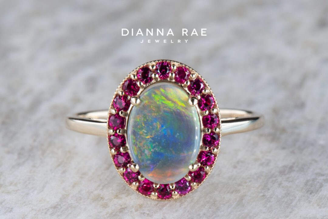 Yellow Gold Oval Black Opal Halo Ring with Ruby Accents