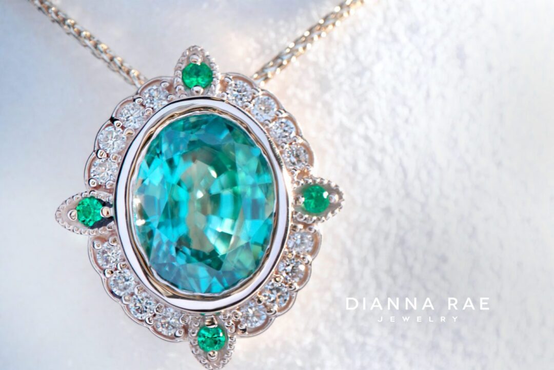 Blue Meridian - Yellow Gold Oval Blue Zircon Vintage-Inspired Halo Pendant with Diamond and Emerald Accents